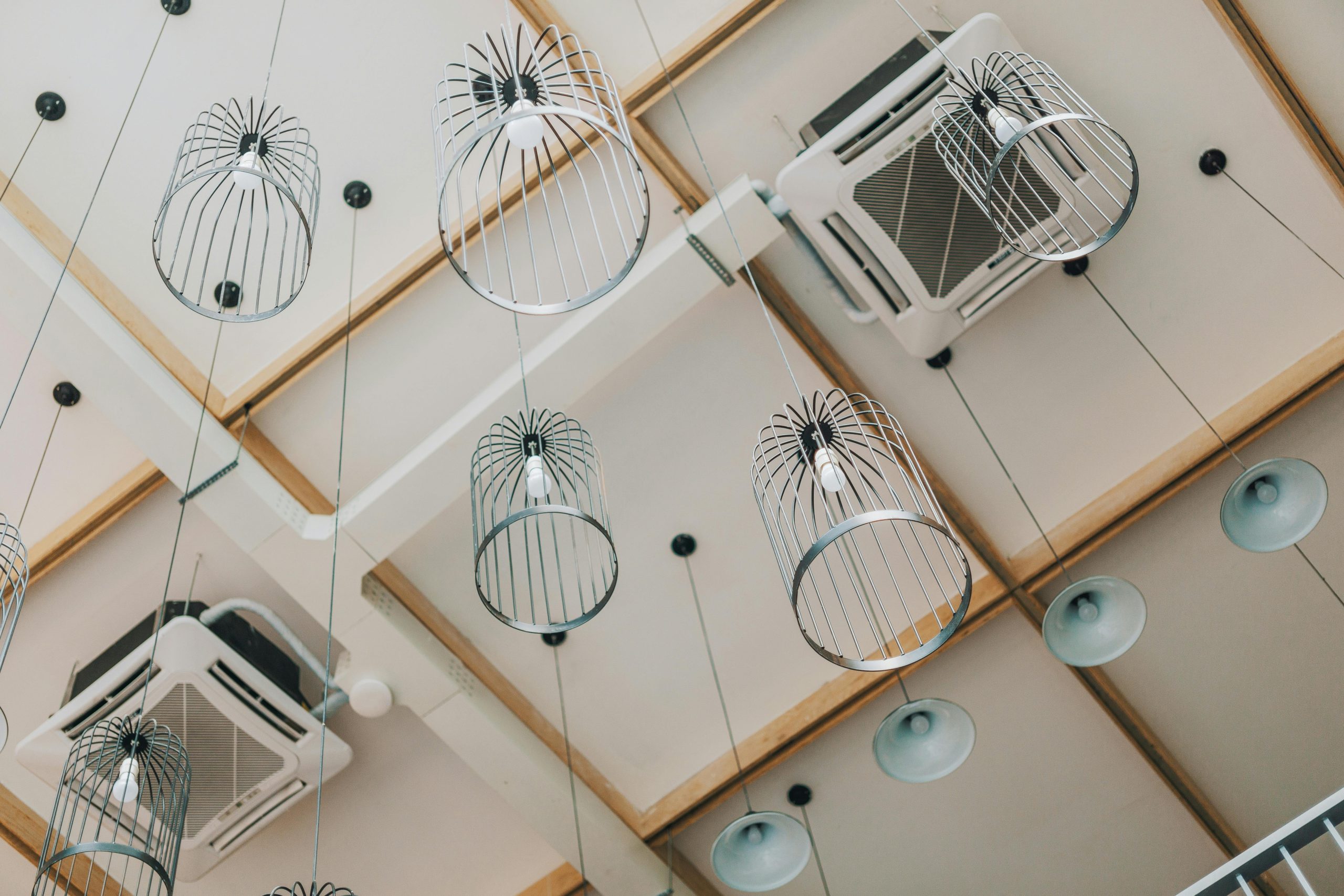 Low angle view of modern pendant lamps in a contemporary interior with a uniquely designed ceiling. Vue en contre-plongée de suspensions modernes dans un intérieur contemporain avec un plafond au design unique.