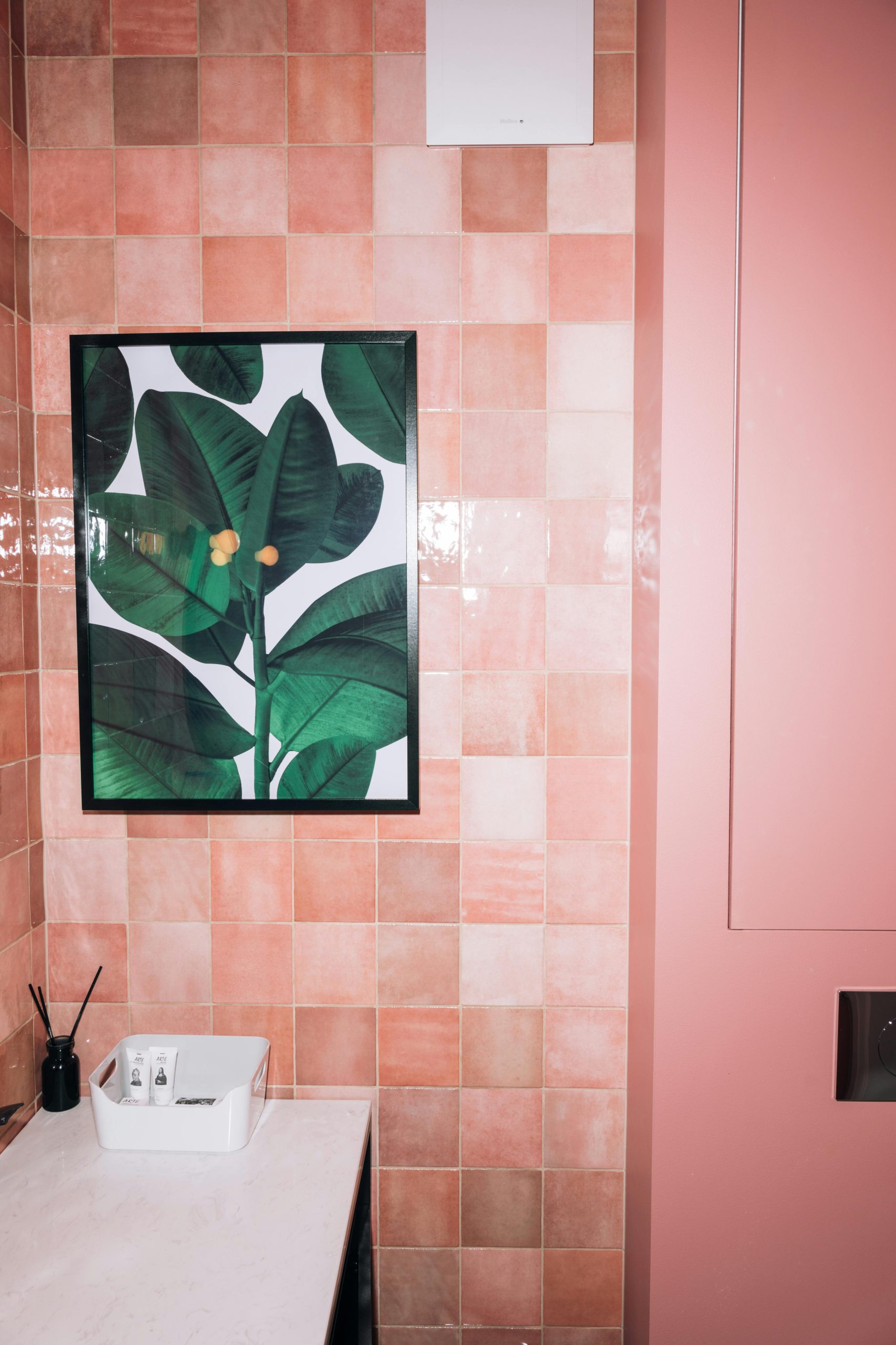 Un luxueux salle de bain rose avec une peinture botanique et une décoration moderne.