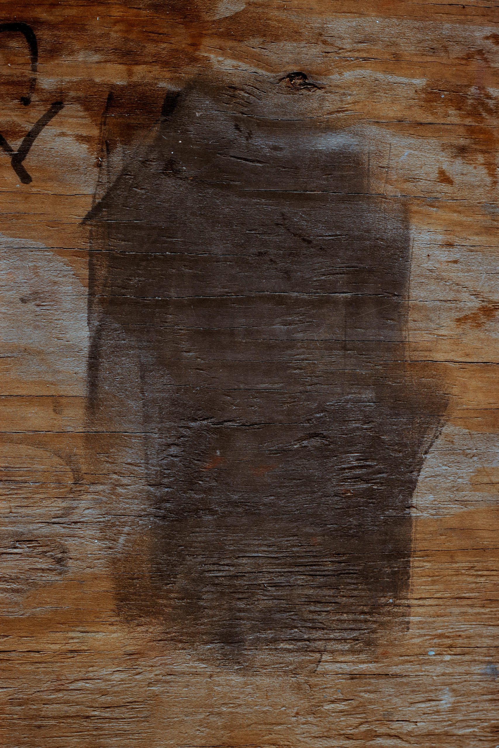 Vue détaillée d'une surface en bois texturée avec une teinte foncée, mettant en valeur les motifs naturels et les traces d'usure.