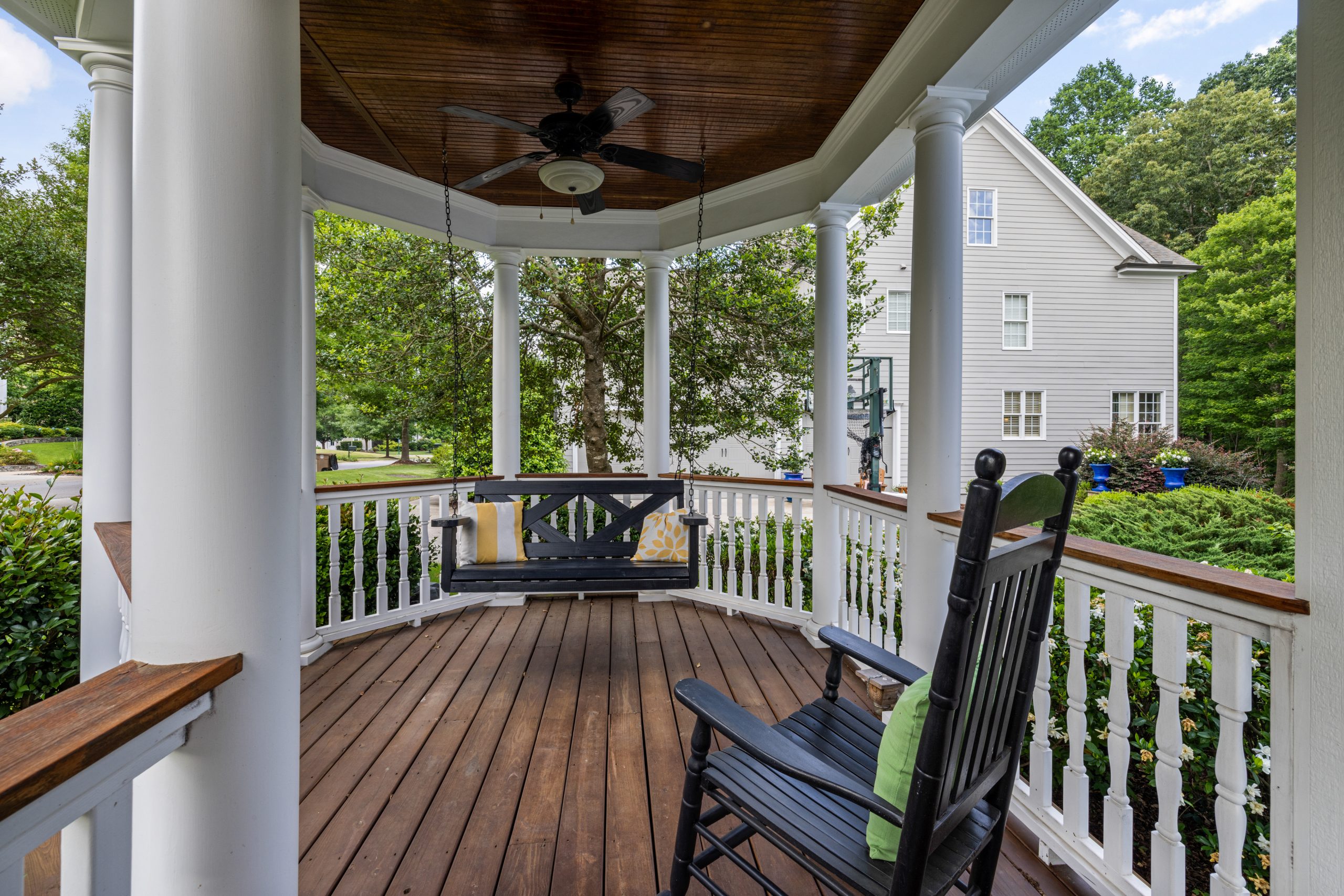 Inviting porch with rocking chair and swing, perfect for relaxation. Un porche accueillant avec une chaise à bascule et une balançoire, parfait pour la détente.