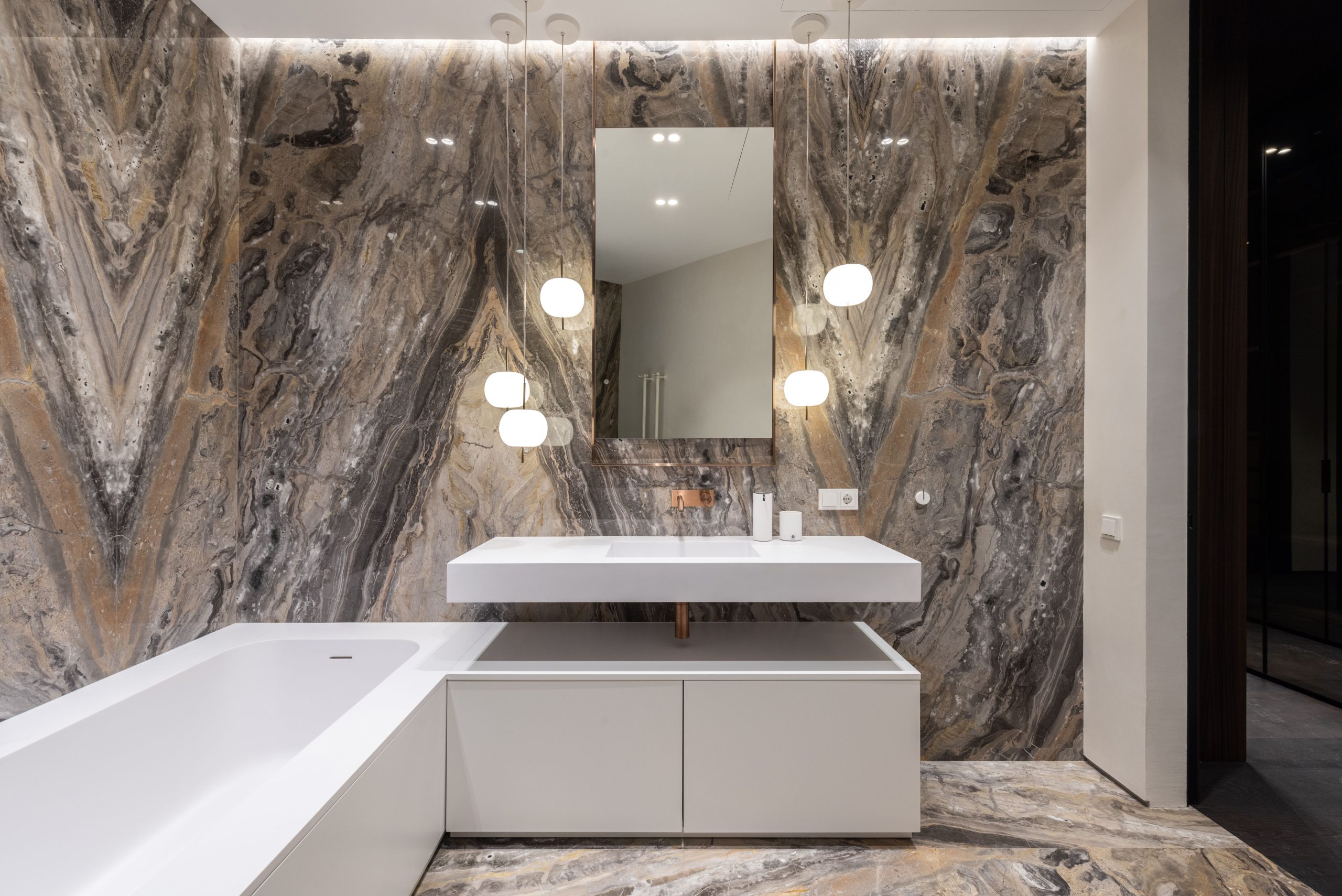 Interior design of modern bathroom with mirror hanging on wall above sink and big bathroom and illuminated with round lamps Design intérieur d'une salle de bain moderne avec miroir suspendu au mur au-dessus de l'évier et grande salle de bain illuminée par des lampes rondes