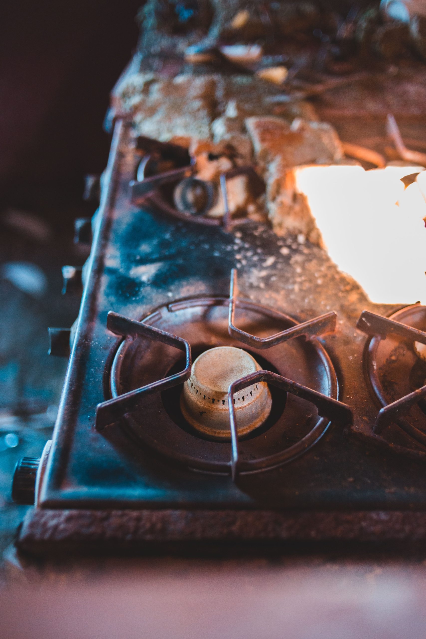 From above of old dirty gas stove placed in old kitchen against blurred background Vue de haut d'une vieille cuisinière à gaz sale placée dans une vieille cuisine sur fond flou.