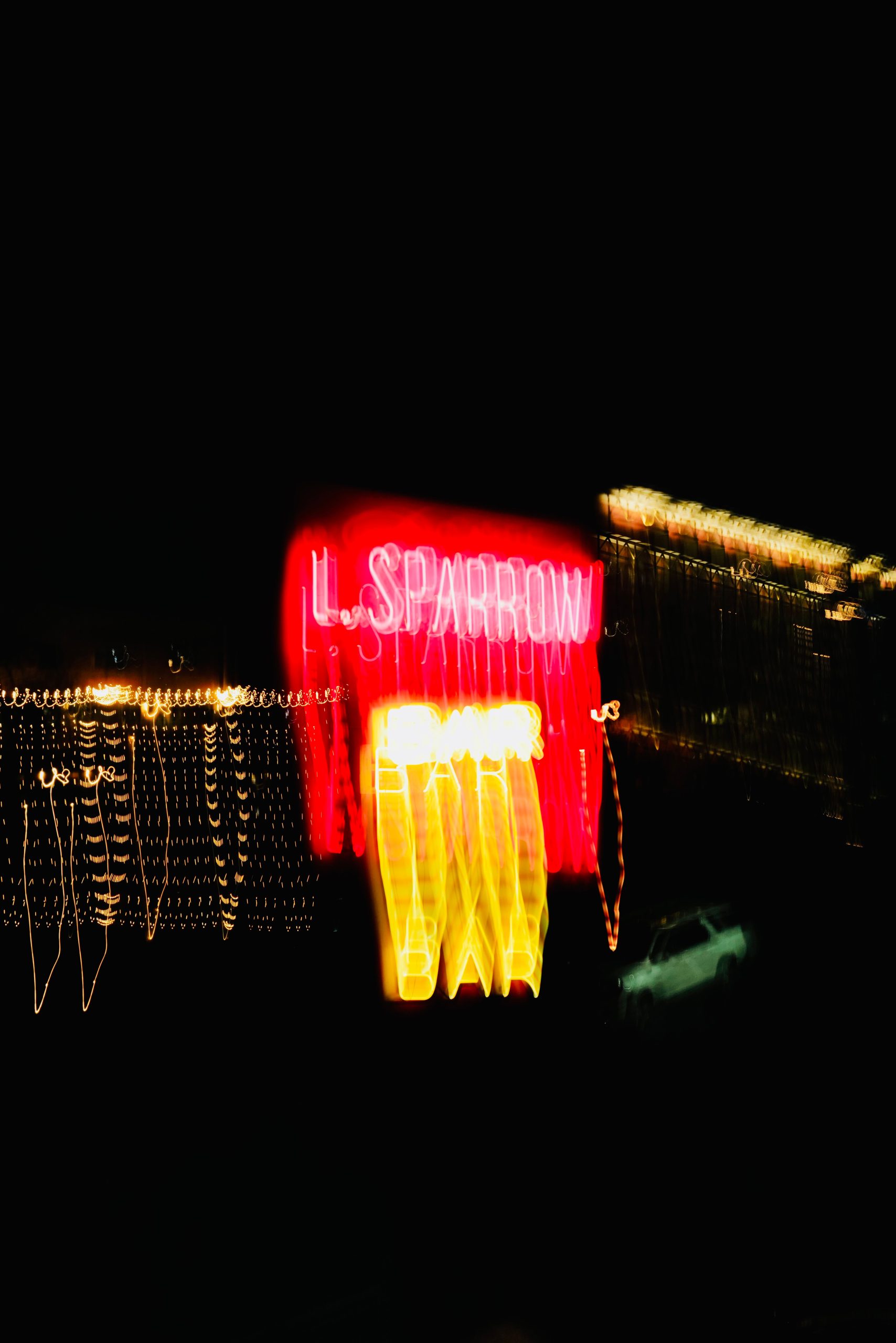 Abstract blur of neon signage and lights creating a vibrant, dynamic scene at night. Flou abstrait d'enseignes au néon et de lumières créant une scène vibrante et dynamique la nuit.