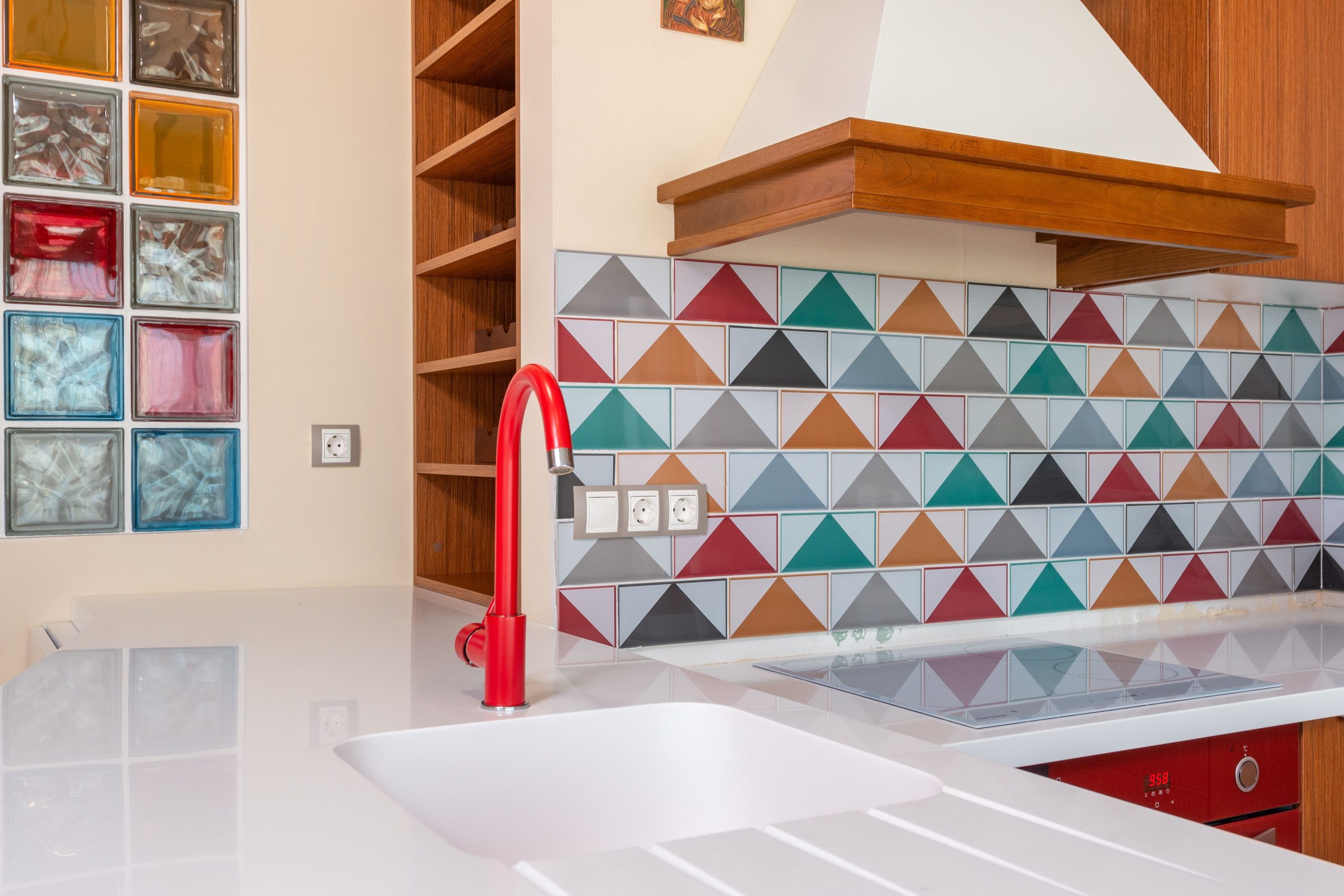 Interior of stylish kitchen with colorful tile and red faucet in modern apartment Intérieur d'une cuisine élégante avec carrelage coloré et robinet rouge dans un appartement moderne
