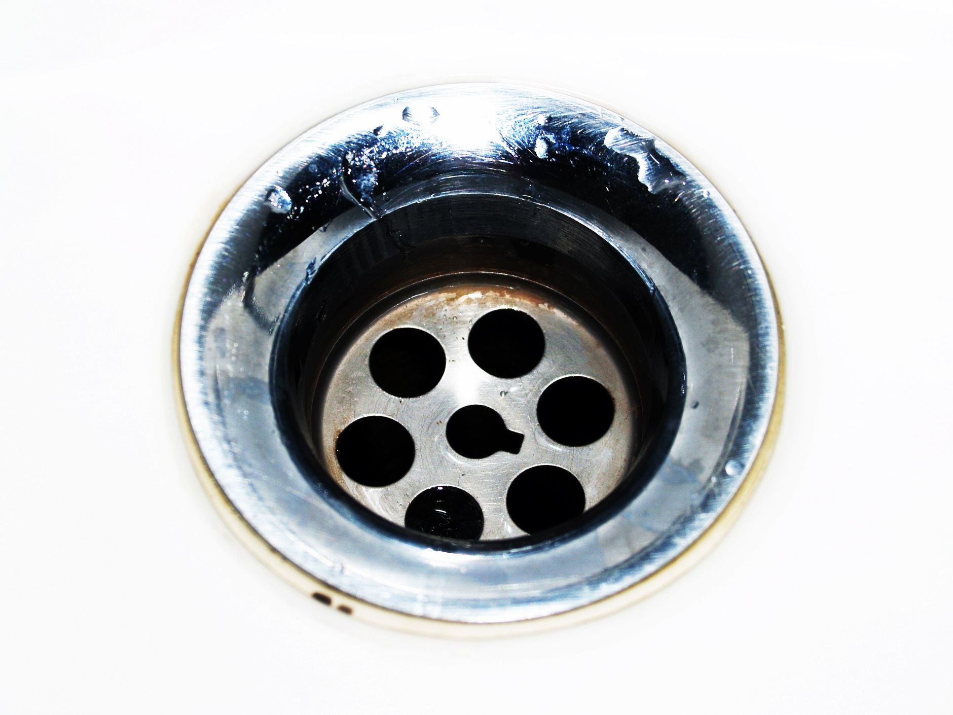 Évacuation chromée d'un évier avec gouttes d'eau