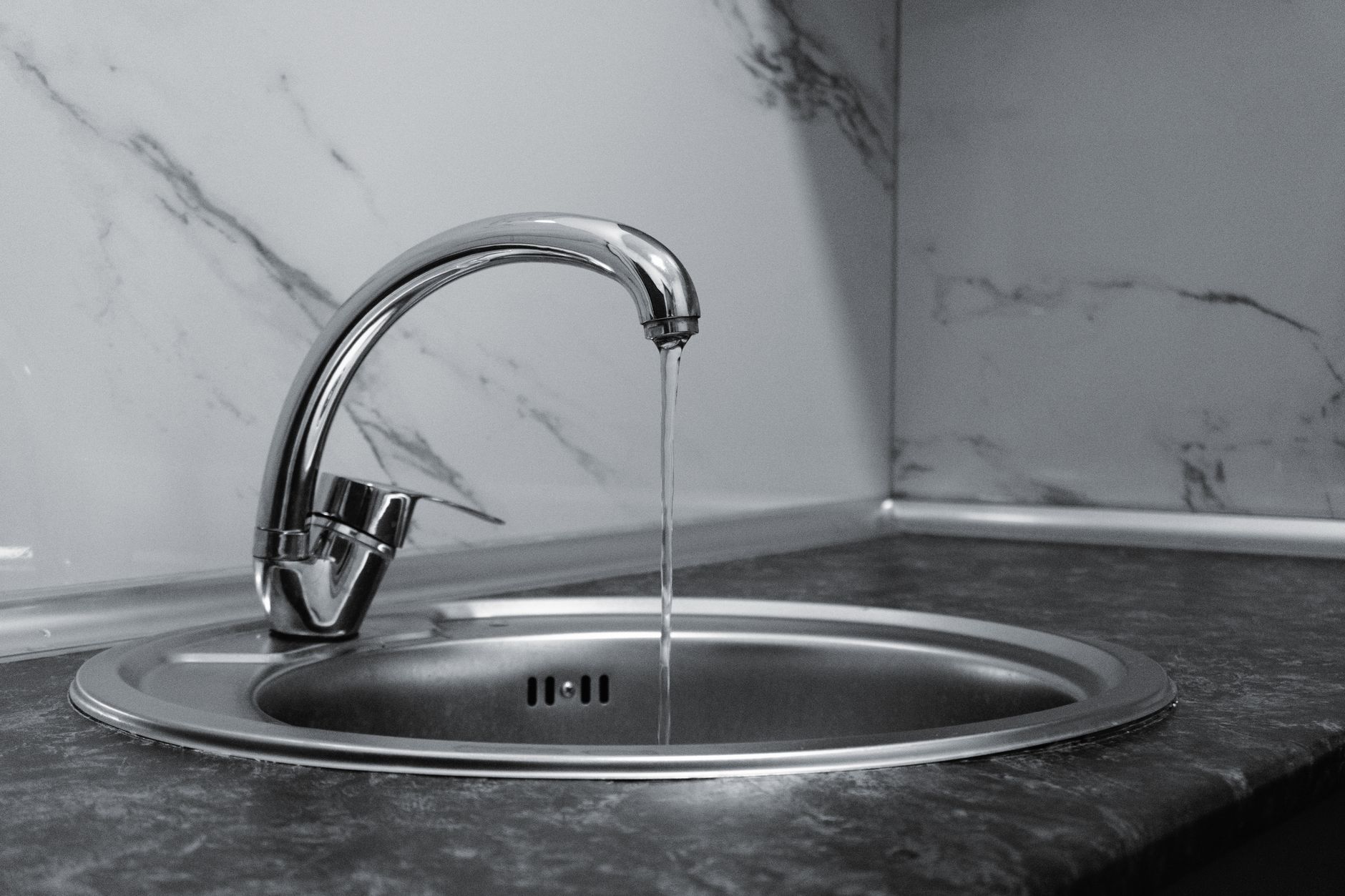 Robinet chromé et eau qui coule dans une cuisine