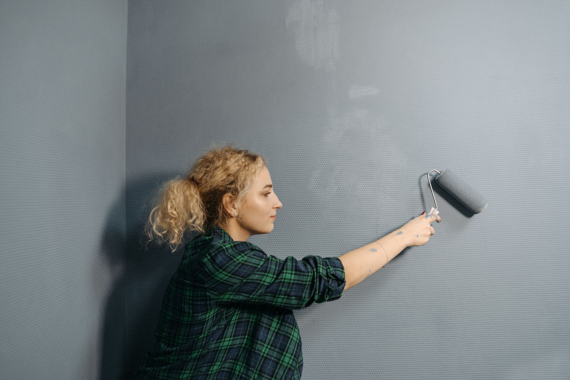 Rouleau de peinture grise appliqué sur un mur intérieur