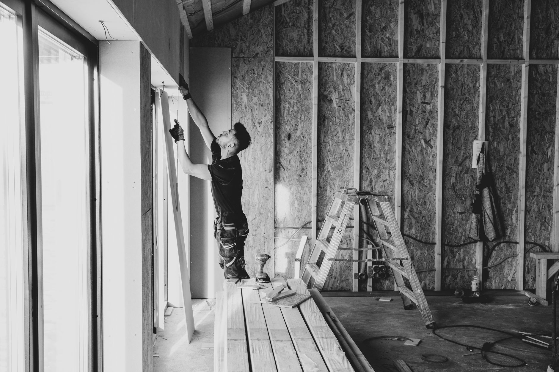 Ouvrier qui installe une plaque de plâtre dans une pièce en rénovation